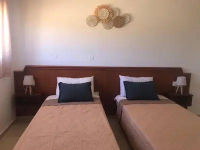 a bedroom with two beds and a clock on the wall at Eirēnē house Afantou in Afantou