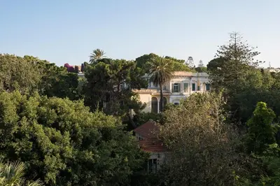 a house on top of a hill with trees at Russelia Suite right in the heart of Rhodes City in Rhodes Town