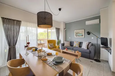 a living room with a table and a couch at Russelia Suite right in the heart of Rhodes City in Rhodes Town
