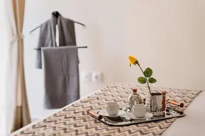 a tray with coffee cups and a flower on a table at Russelia Suite right in the heart of Rhodes City in Rhodes Town