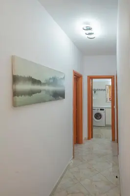 a hallway with a painting on a white wall at Golden Grove in Afantou