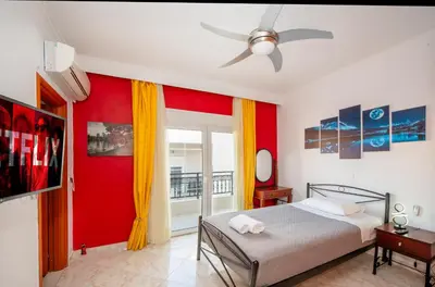 a bedroom with a bed and a red wall at Golden Grove in Afantou