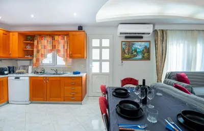 a kitchen and living room with a table and a couch at Golden Grove in Afantou