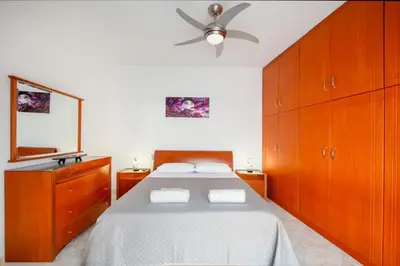 a bedroom with a bed and a ceiling fan at Golden Grove in Afantou