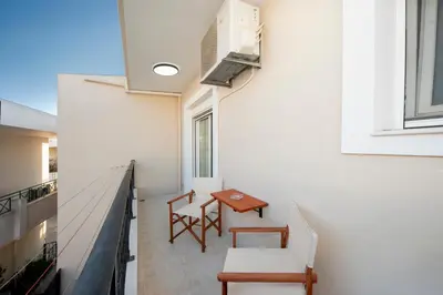 a balcony with a table and chairs on a building at Golden Grove in Afantou