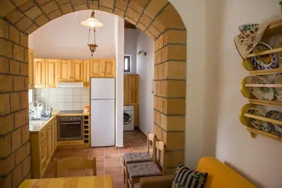 a kitchen with an archway with a white refrigerator at Traditional Stay in Archangelos