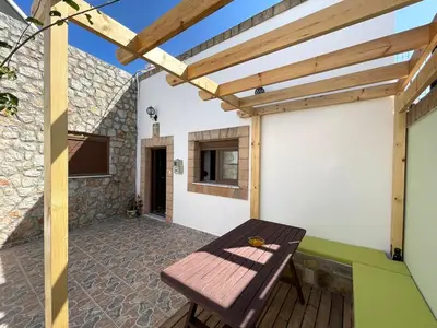 a patio with a wooden table and a wooden pergola at Traditional Stay in Archangelos
