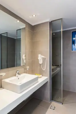 a bathroom with a sink and a glass shower at Lindos Portes Blue in Líndos
