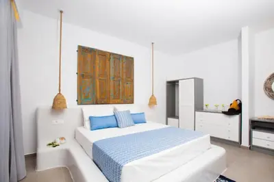 a white bedroom with a bed and a bath tub at Lindos Portes Blue in Líndos