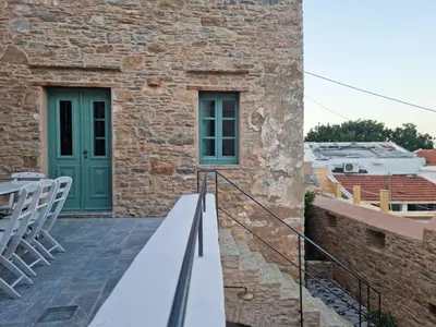 a stone building with a green door and a balcony at Symi Village House in Symi