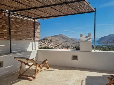 a chair on the roof of a house with a view at Symi Village House in Symi