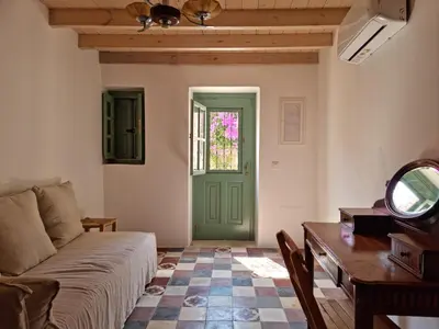 a living room with a green door and a table at Symi Village House in Symi