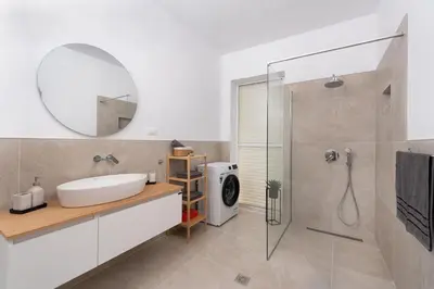 a bathroom with a sink and a shower with a mirror at Ferienwohnung BIA Rigas in Rhodes Town