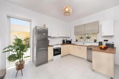 a kitchen with white cabinets and a stainless steel refrigerator at Ferienwohnung BIA Rigas in Rhodes Town