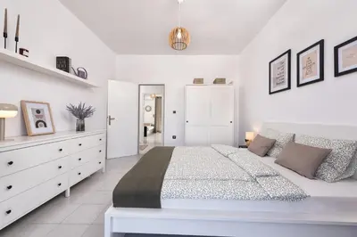 a white bedroom with a large bed and white cabinets at Ferienwohnung BIA Rigas in Rhodes Town