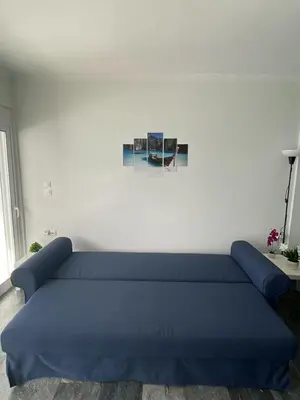 a blue couch in a room with a white wall at Diogenis seaside apartment in Rhodes Town