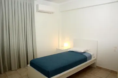 a small bedroom with a bed and a window at Diogenis seaside apartment in Rhodes Town