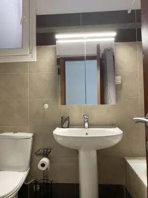 a bathroom with a sink and a toilet and a mirror at Diogenis seaside apartment in Rhodes Town