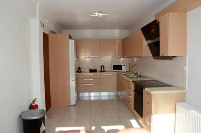 a small kitchen with wooden cabinets and a sink at Diogenis seaside apartment in Rhodes Town