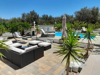 a patio with chairs and an umbrella and a pool at Diotima Rhodos Experience in Rhodes Town