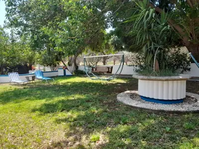 a park with a tree and a swing at Diotima Rhodos Experience in Rhodes Town