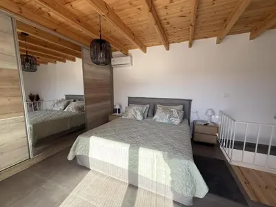 a bedroom with a bed and a wooden ceiling at Spitaki in Kremasti