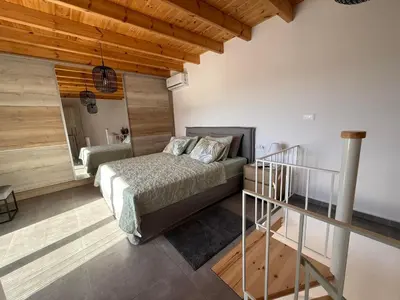 a bedroom with a bed and a staircase in a room at Spitaki in Kremasti