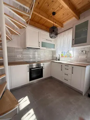 a kitchen with white cabinets and a wooden ceiling at Spitaki in Kremasti