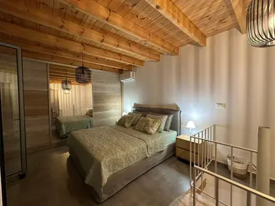 a bedroom with a bed in a room with wooden ceilings at Spitaki in Kremasti