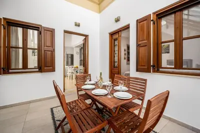 a dining room with a wooden table and chairs at Villa Yannis in Líndos