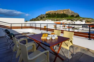 a table and chairs on a balcony with a view at Villa Yannis in Líndos