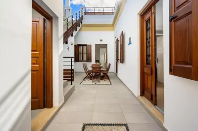 a corridor of a house with wooden doors and a table at Villa Yannis in Líndos