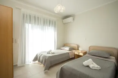 a bedroom with two beds and a large window at Beachfront Villa Rhodes SeaShell in Gennadi