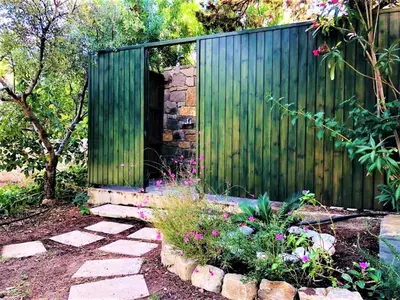 a garden with a green fence and some flowers at Beachfront Villa Rhodes SeaShell in Gennadi