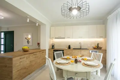 a kitchen with a white table and white chairs at Beachfront Villa Rhodes SeaShell in Gennadi