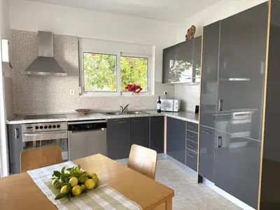 a kitchen with gray cabinets and a wooden table at Villa Fig Tree in Phanaes