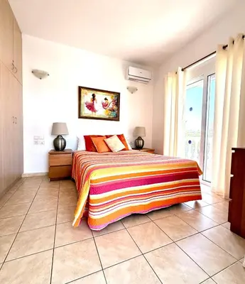 a bedroom with a bed with a colorful blanket on it at Villa Fig Tree in Phanaes