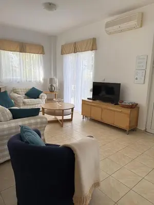 a living room with two couches and a tv at Villa Fig Tree in Phanaes