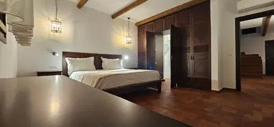 a bedroom with a bed and a table in it at Fournos Traditional Luxury Villa - Stegna Rhodes in Vrachonisída touArchangélou
