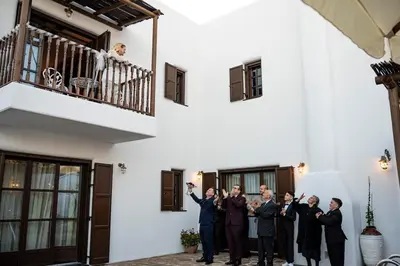 a group of men cheering in front of a building at Fournos Traditional Luxury Villa - Stegna Rhodes in Vrachonisída touArchangélou