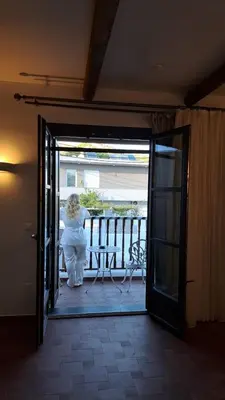 a woman in a white dress standing on a balcony at Fournos Traditional Luxury Villa - Stegna Rhodes in Vrachonisída touArchangélou