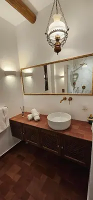 a bathroom with a sink and a large mirror at Fournos Traditional Luxury Villa - Stegna Rhodes in Vrachonisída touArchangélou