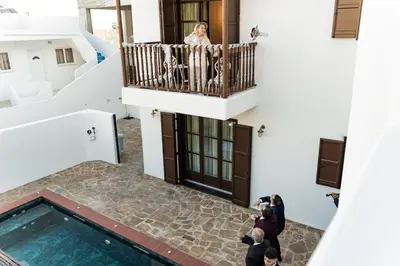a woman standing on the balcony of a building at Fournos Traditional Luxury Villa - Stegna Rhodes in Vrachonisída touArchangélou