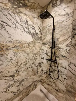 a shower in a bathroom with a marble wall at Casa Trees Boutique Hotel in Ixia