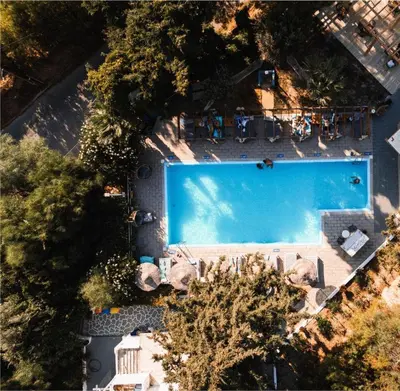 an overhead view of a large swimming pool with people sitting around it at Casa Trees Boutique Hotel in Ixia