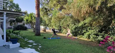two people are exercising in a yard at Casa Trees Boutique Hotel in Ixia