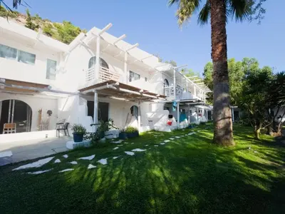 a white house with a palm tree in the yard at Casa Trees Boutique Hotel in Ixia