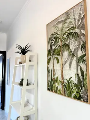 a painting hanging on a wall next to a white shelf at Andreana s View House Rhodes in Asgourou