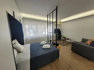a bedroom with a bed and a couch at Hyacinthus city apartment in Rhodes Town