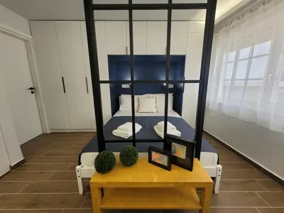 a bedroom with a four poster bed with a table at Hyacinthus city apartment in Rhodes Town